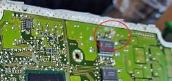 Zdjęcie wnętrza płytki drukowanej ze zbliżeniem na skorodowane elementy elektroniczne.