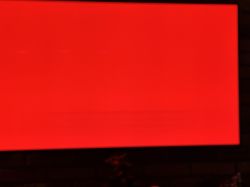Telewizor OLED wyświetlający czerwony ekran z widocznym poziomym pasem na matrycy.