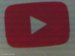 Zbliżenie wyświetlacza z logo YouTube, widoczne są piksele ekranu.