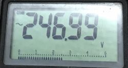 Multimeter display showing a voltage of 246.99 V.