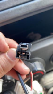 Nahaufnahme eines Autoradio-Steckers, der in einer Hand gehalten wird.