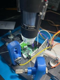 Worktable with a digital microscope over open electronics.