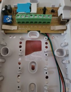 Close-up of the circuit board and screw terminals inside a Comelit 2602 intercom, terminal labels visible.
