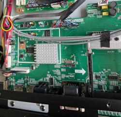 Motherboard with multiple connectors, wires, and an aluminum heatsink