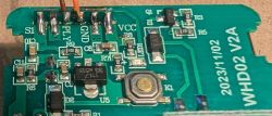 Close-up of a WHD02 V2A PCB with electronic components and labeled terminals.