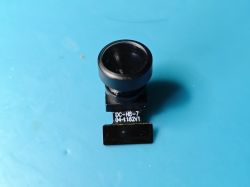 Mini camera module DC-H8-7 on a blue background A small camera module with a wide-angle black lens on a flat cable labeled DC-H8-7 04-1182V1, placed on a blue background.