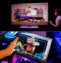 Dwa zdjęcia pokazujące technologię holograficzną. Pierwsze to duży monitor z holograficznym obrazem opakowań i biletów. Drugie to ręce trzymające mniejszy holograficzny wyświetlacz przedstawiający postać lisa.