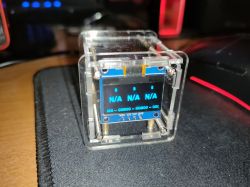 Small electronic module in a clear case; the OLED screen shows “N/A”.