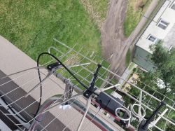 Antena siatkowa na balustradzie balkonu z zamocowanym dipolem i przewodem koncentrycznym