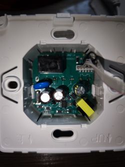 Thermostat PCB with capacitors, relay socket, and wire connectors inside housing