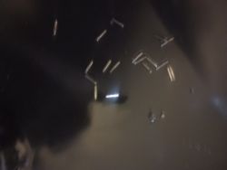 Fragmenty metalu na dnie czarnej miski olejowej.