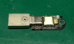 Moduł elektroniki z wtykiem USB i małą baterią na płytce, na zielonej macie
