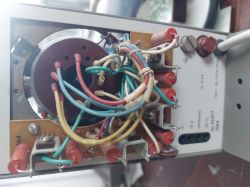 Zbliżenie na wewnętrzne okablowanie starego urządzenia elektronicznego z przewodami i potencjometrem.