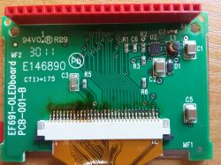 Grüne Leiterplatte mit verschiedenen elektronischen Komponenten, einschließlich eines roten Steckverbinders.