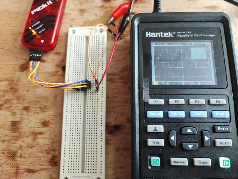 Hantek Oscilloscope with Breadboard Top view of a handheld Hantek oscilloscope and a breadboard with prototype connections.