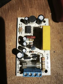 Płytka elektroniczna z bezpiecznikiem i niebieską listwą zaciskową na drewnianym tle