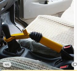 Żółta blokada antykradzieżowa na dźwigni zmiany biegów w samochodzie.