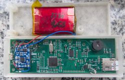Wnętrze prototypowego rejestratora GPS z widocznym układem elektronicznym i akumulatorem.