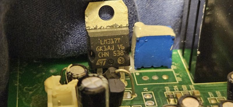 Zbliżenie układu LM317T na płytce drukowanej z widocznymi komponentami elektronicznymi