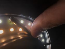Close-up of Wire Manipulation near LED Strip Close-up of a hand holding a wire next to an LED strip.