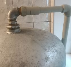 Metalowy zbiornik z armaturą i rurą w środowisku hydraulicznym