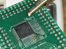 Close-up of a TQFP integrated circuit soldered onto a PCB.