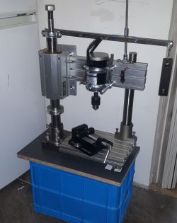 Homemade drilling and tapping machine mounted on a blue crate.