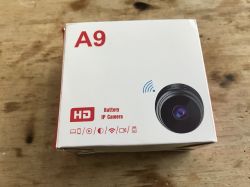 A9 IP camera box with device image and function icons on wooden surface.