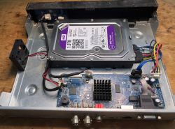 Wnętrze metalowej obudowy z dyskiem WD Purple 1TB i płytą główną z radiatorem oraz okablowaniem