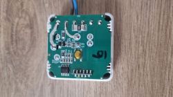 Printed circuit board with electronic components on a wooden background.