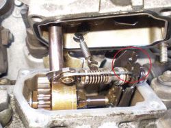 Wnętrze pompy z widocznymi sprężynami i kołami zębatymi; czerwone kółko zaznacza prawą część mechanizmu.