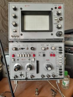 Dwa stare oscyloskopy Unitra OS-710 i Y-701 na biurku z podłączonym przewodem