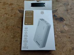 Opakowanie powerbanku Romoss sense 4SF 10000 mAh na drewnianym blacie roboczym.