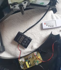 Panel sterujący urządzenia z wyświetlaczem, pilotem i płytką elektroniczną na białym podłożu.