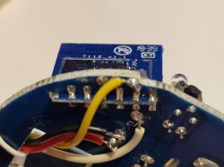 Close-up of a device interior: PCB with soldered wires and electronic components.