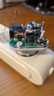 Close-up of smart plug interior with CB2S module and electronic components visible