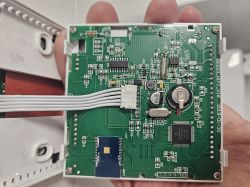 Thermostat interior showing PCB with cable connector, Wi-Fi module, and electronic components