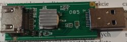 Moduł elektroniczny z portami USB i HDMI na tle tekstu.