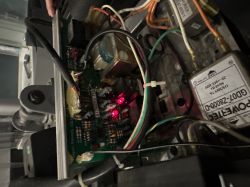 Wnętrze urządzenia elektronicznego z widocznymi przewodami i komponentami.