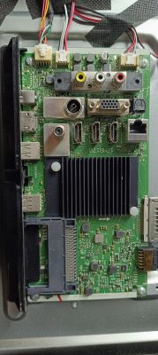Mainboard with various input/output ports inside a TV or monitor housing.