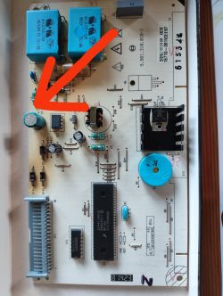 Płytka elektroniczna z oznaczeniami i strzałką wskazującą na wymieniony komponent.