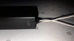 Modifiziertes Batteriegehäuse mit USB-C Nahaufnahme eines schwarzen Batteriegehäuses mit USB-C-Anschluss und zwei weißen Drähten.