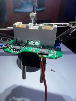 PCB held by a service holder with connected power supply.