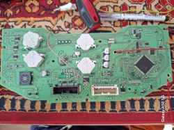 Płytka PCB zespołu wskaźników z czarnym i białym złączem; widoczne przewody i narzędzia.