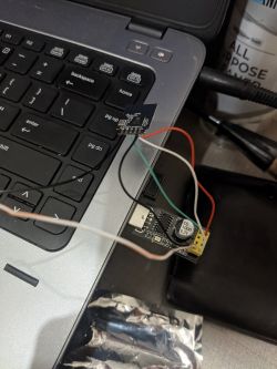 USB to UART adapter connected to a laptop with colored wires.