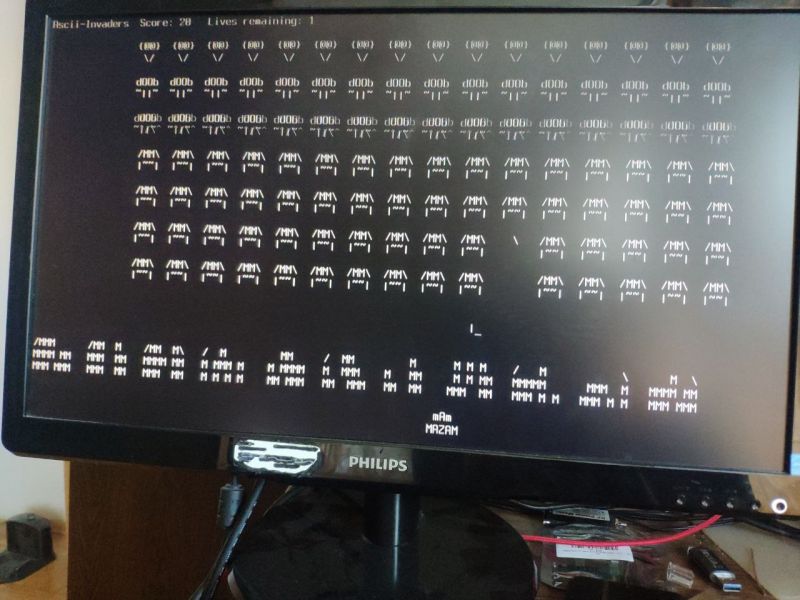 Monitor wyświetlający grę Ascii-Invaders w trybie tekstowym na czarnym tle