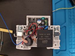 Open electronics enclosure with PCB, JYONN relay, and red/blue wires on a work mat