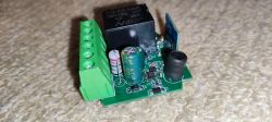 PCB with a relay and CB2S module on a beige surface.