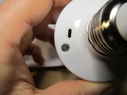 LED Bulb Held in Hand Hand holding an LED bulb with connector details.