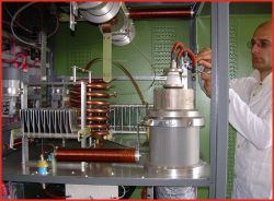 Technik pracuje przy generatorze o konstrukcji lampowej z cewkami i elektrodami